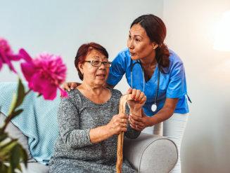 nurse assisting elderly woman sitting