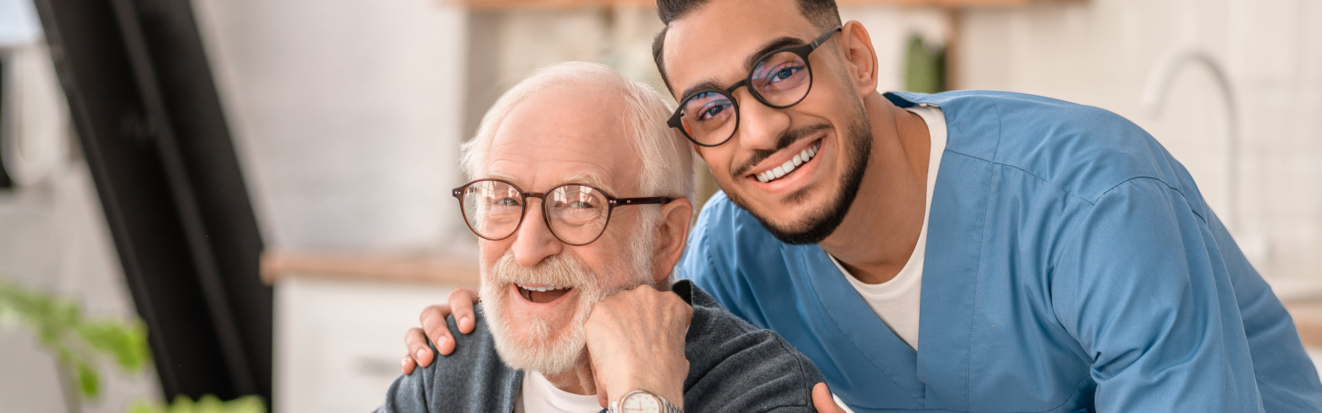 nurse and elderly man smiling and looking at the camera