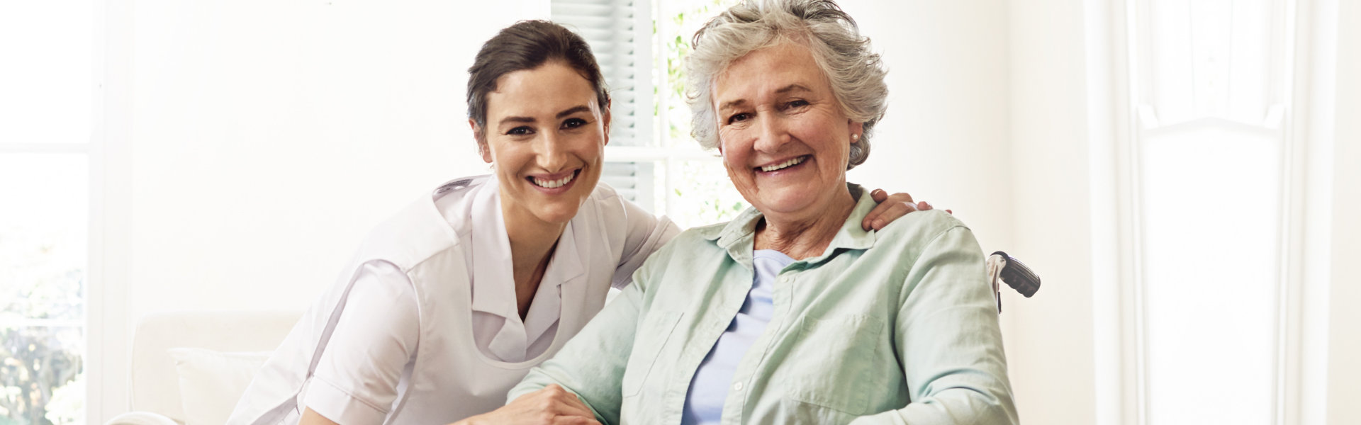 nurse and elderly woman looking at the camera