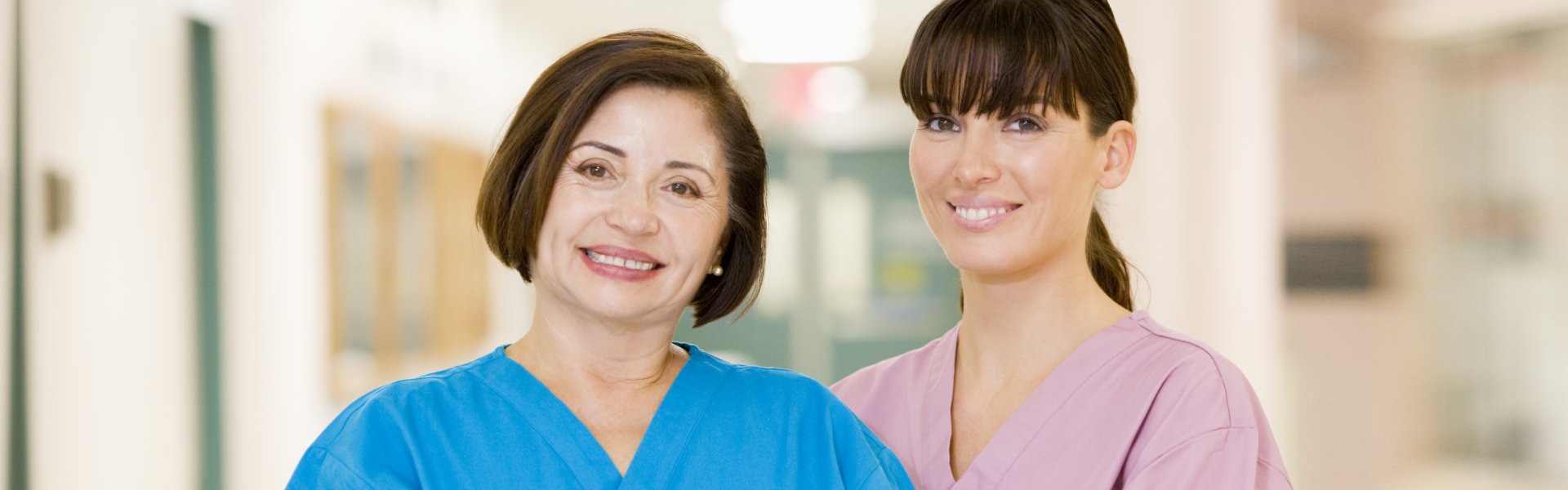 two nurse smiling and looking at the camera